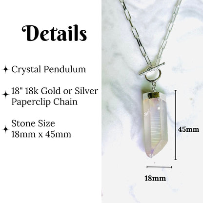 Crystal pendant necklace with a silver paperclip chain on a white marble background, with text detailing the 18mm x 45mm stone size and 18k gold or silver chain.