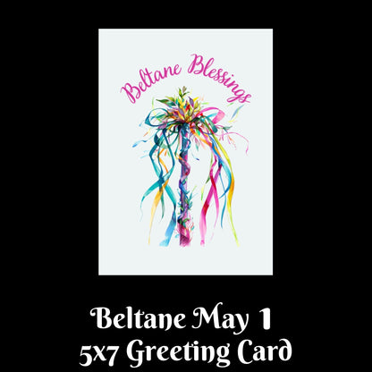A 5x7 greeting card design shown on a black background with text below reading 'Beltane May 1 5x7 Greeting Card.' The card features a white center with a colorful watercolor-style decorative bow or floral ribbon illustration and pink script text reading 'Beltane Blessings.