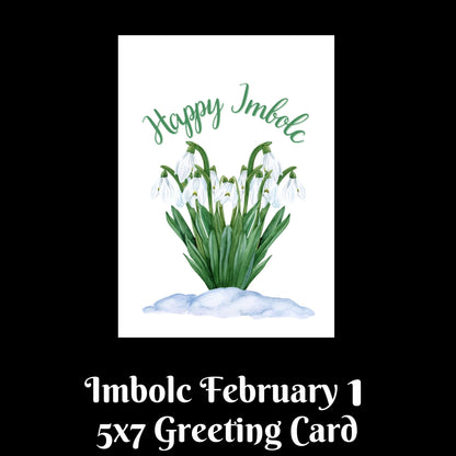 A greeting card design shown on a black background with text below reading 'Imbolic February 1 5x7 Greeting Card.' The central card features a white background with a watercolor-style green plant and white blossoms, and the words 'Happy Imbolic' in green script above it.