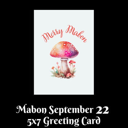 A 5x7 greeting card design shown on a black background with text below reading ' Mabon September 22' and '5x7 Greeting Card.' The card features a white center with a watercolor-style mushroom illustration in pink, orange, and purple tones, plus the words 'Merry Mabon' in coral script at the top.